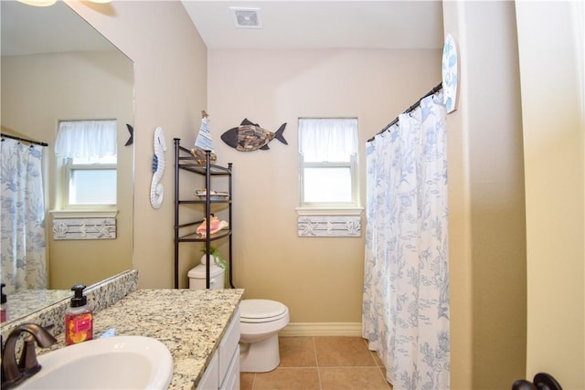 full bath featuring toilet, healthy amount of natural light, vanity, and tile patterned flooring