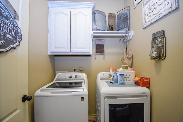 laundry area with independent washer and dryer and cabinet space