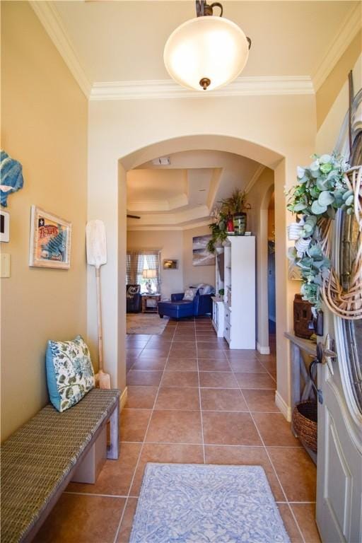 hallway featuring crown molding, arched walkways, and tile patterned flooring