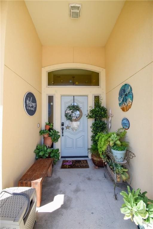 entrance to property with stucco siding and a porch