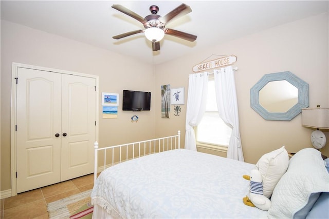 bedroom featuring light tile patterned flooring, a closet, and ceiling fan