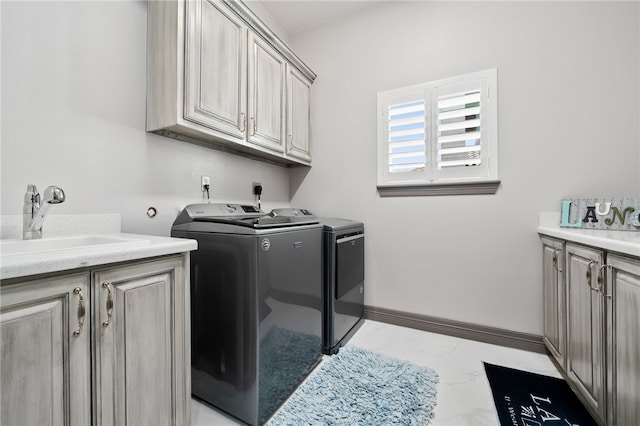 clothes washing area featuring cabinets, sink, and independent washer and dryer