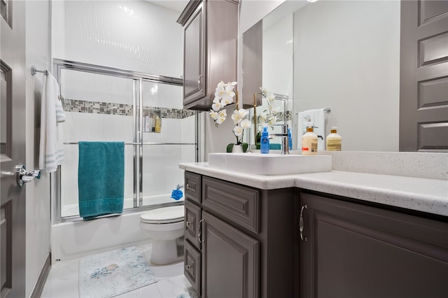 full bathroom with enclosed tub / shower combo, vanity, and toilet