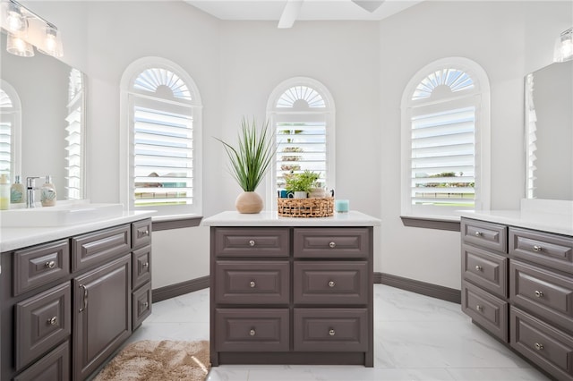 kitchen with dark brown cabinetry, a wealth of natural light, ceiling fan, and sink