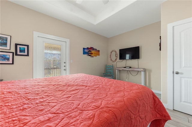 bedroom featuring access to exterior, light hardwood / wood-style floors, and ceiling fan