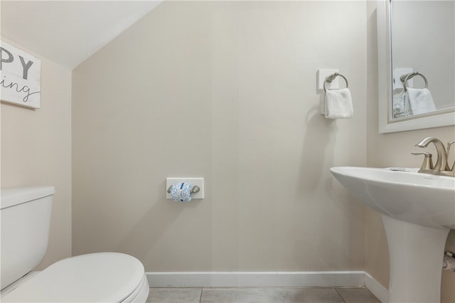 bathroom featuring tile patterned floors, sink, lofted ceiling, and toilet