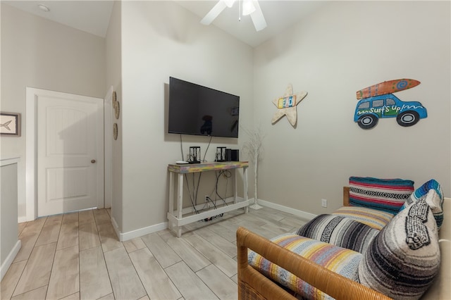 living room with ceiling fan, high vaulted ceiling, and light hardwood / wood-style flooring