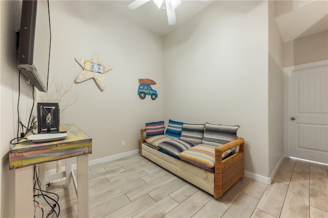 sitting room featuring light hardwood / wood-style floors, ceiling fan, and lofted ceiling