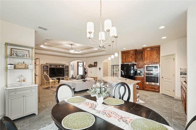 3137 Piranha Dr, Corpus Christi, TX 78414 - dining room with arched walkways, a tray ceiling, a chandelier, ceiling fan, and recessed lighting