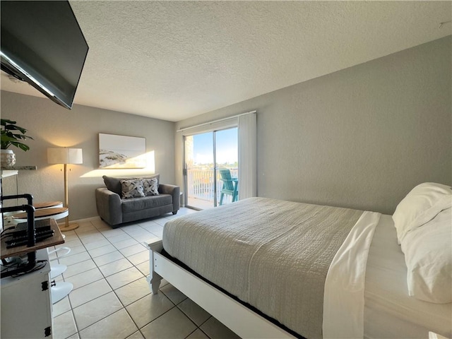 bedroom with access to exterior, light tile patterned floors, a textured ceiling, and a textured wall