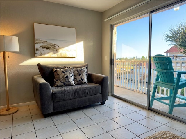 living area featuring light tile patterned flooring and baseboards