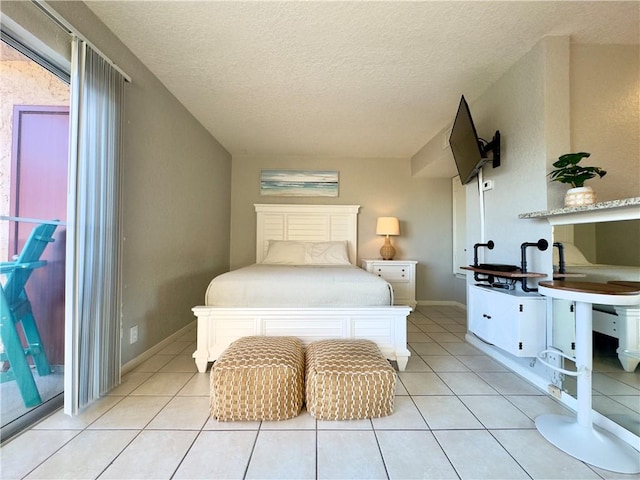 bedroom featuring a textured ceiling, light tile patterned flooring, and baseboards