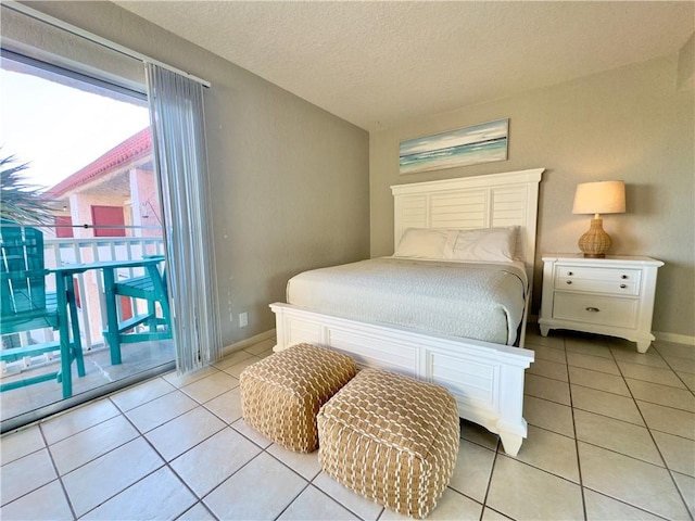 bedroom featuring a textured ceiling, access to outside, light tile patterned flooring, and baseboards