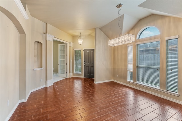 unfurnished room with dark wood-type flooring, vaulted ceiling, and an inviting chandelier