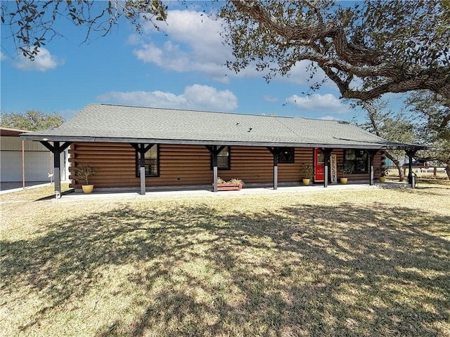 view of front of property featuring log siding, a shingled roof, and a front yard