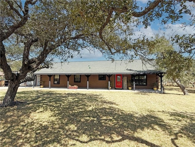 view of front of house with log siding, a porch, and a front yard