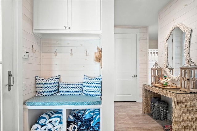 mudroom featuring wooden walls and light wood-style floors