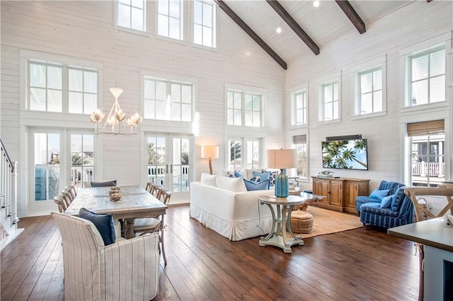 sunroom / solarium featuring vaulted ceiling with beams, a wealth of natural light, french doors, and a notable chandelier