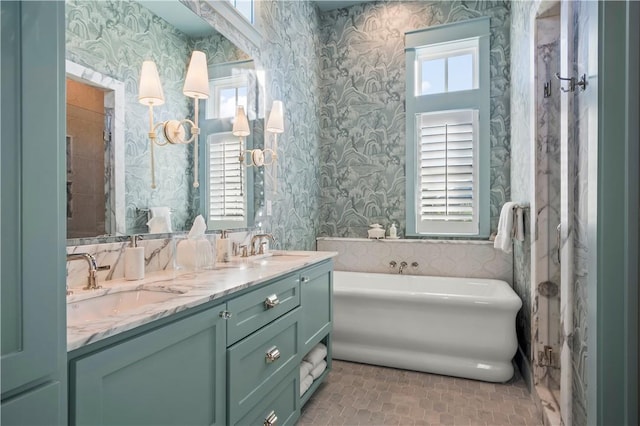 bathroom featuring wallpapered walls, a wealth of natural light, and a sink