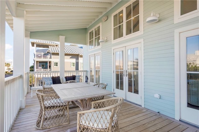 wooden terrace featuring french doors and outdoor dining area