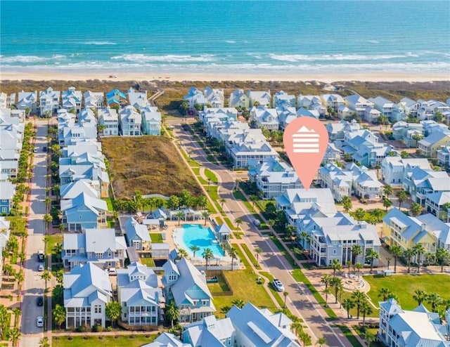 drone / aerial view with a water view, a view of the beach, and a residential view