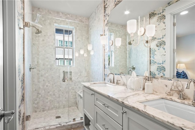 full bath featuring double vanity, a sink, and a shower stall