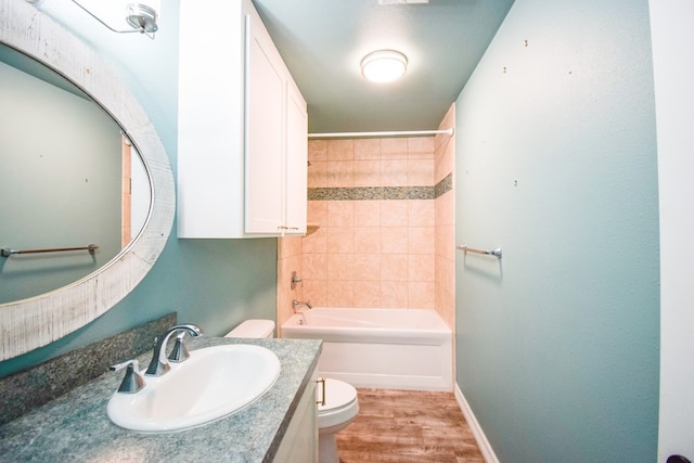 full bathroom featuring hardwood / wood-style flooring, tiled shower / bath, vanity, and toilet