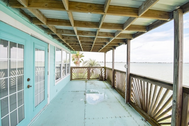 balcony featuring french doors and a water view