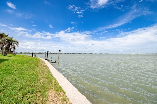 dock area featuring a water view and a lawn