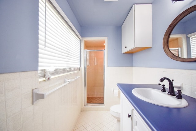 bathroom with vanity, toilet, a shower with shower door, and tile patterned flooring