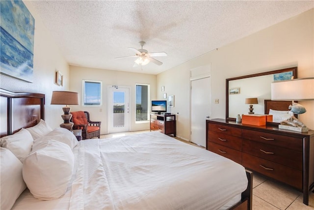 bedroom with access to outside, a textured ceiling, light tile patterned floors, and a ceiling fan