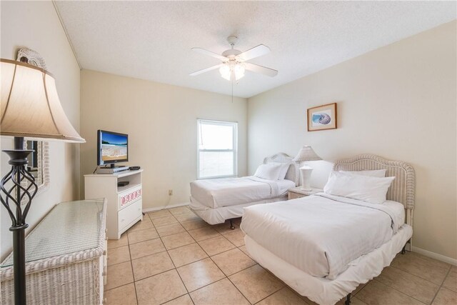 bedroom featuring light tile patterned floors, ceiling fan, and baseboards