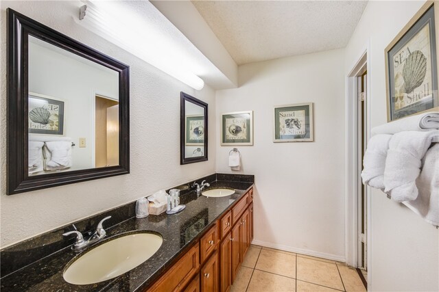 bathroom with tile patterned flooring, vanity, and a textured ceiling