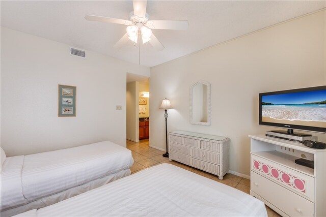 tiled bedroom with ceiling fan and connected bathroom