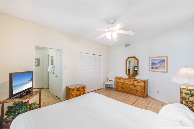 bedroom with light tile patterned flooring, ceiling fan, and a closet