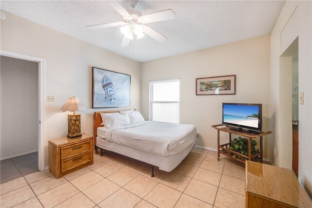 bedroom with ceiling fan, a textured ceiling, and light tile patterned floors