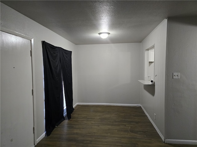 corridor with dark hardwood / wood-style floors and a textured ceiling