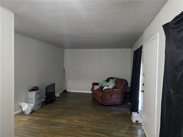 living area featuring a textured ceiling and dark hardwood / wood-style floors