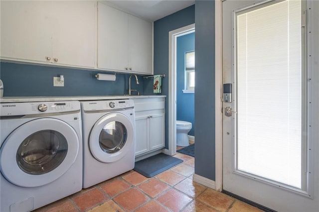 clothes washing area with cabinet space, independent washer and dryer, baseboards, and light tile patterned floors