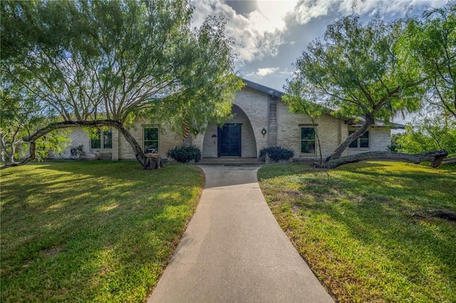single story home with brick siding and a front yard