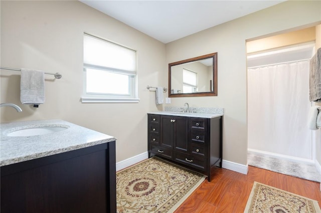 full bath with baseboards, wood finished floors, vanity, and a shower with shower curtain