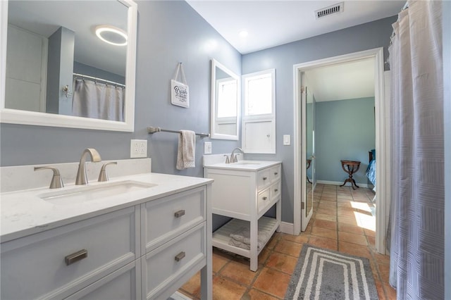 full bath featuring two vanities, tile patterned flooring, a sink, and visible vents