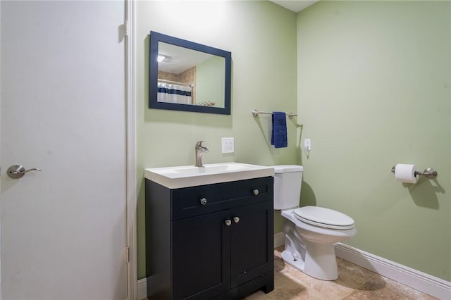 full bathroom with toilet, vanity, and baseboards