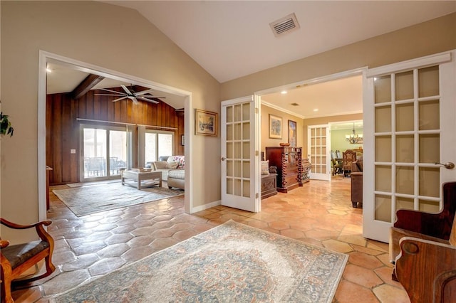 interior space featuring french doors, baseboards, visible vents, lofted ceiling, and ceiling fan with notable chandelier
