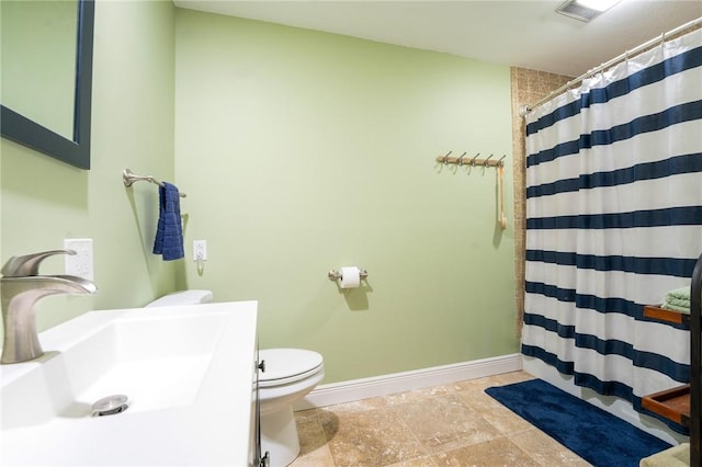 full bath featuring a shower with shower curtain, toilet, baseboards, and a sink