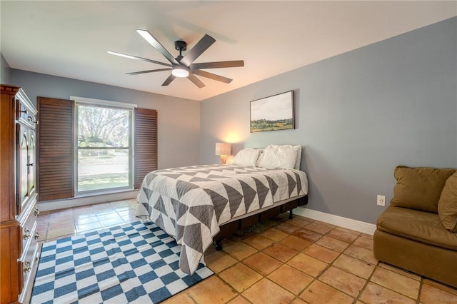 bedroom with a ceiling fan and baseboards