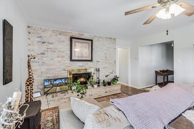 living room featuring ceiling fan, a fireplace, and hardwood / wood-style flooring