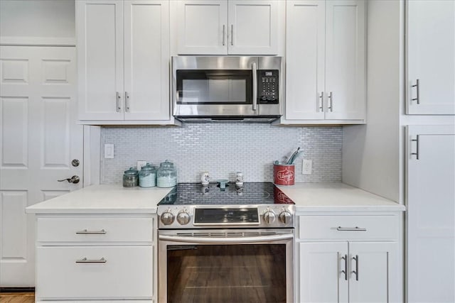 kitchen with appliances with stainless steel finishes, white cabinets, and decorative backsplash