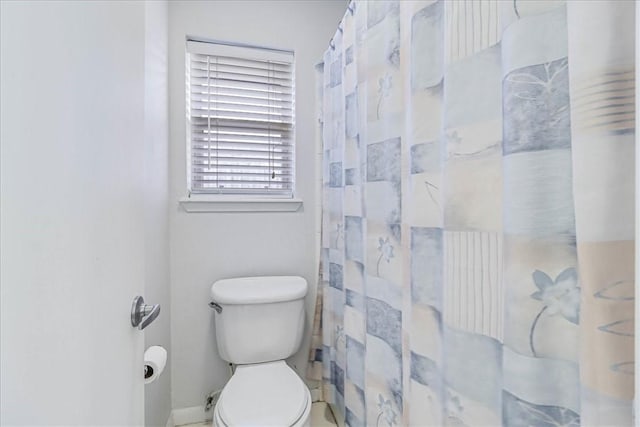 bathroom featuring a shower with shower curtain and toilet