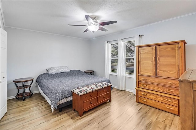 bedroom featuring ceiling fan, light wood-type flooring, crown molding, and a textured ceiling